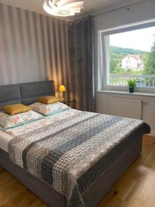 Schlafzimmer mit einem großen Bett und einem Fenster in der Unterkunft Apartament Odpoczynek in Ustrzyki Dolne