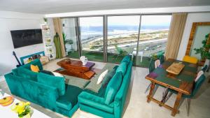 una sala de estar con muebles azules y una gran ventana. en Sea View B16 - Mosqué Hassan II - By TheCasaEdition en Casablanca