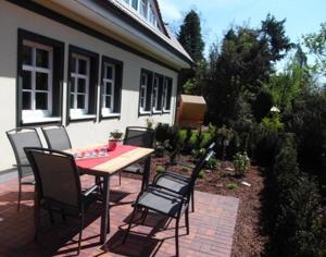 a patio with a table and chairs in front of a house at "Zingster Traum 2" Müggenburger Weg 36 a in Groß Kirr