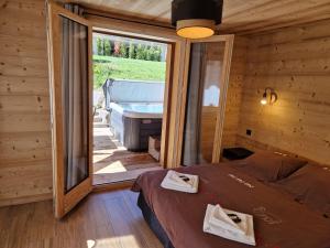Chalet Delphinette - Spa privatif في مورزين: غرفة نوم بسرير وحوض في كابينة