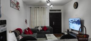 un soggiorno con divano e TV di Emani Luxury Condo a Nakuru
