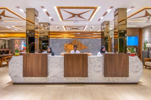 a lobby with three people sitting at a counter at Triton Prestige Seaview and Spa in Maafushi