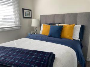 a bedroom with a bed with blue and yellow pillows at Hammer Haus II in Waterloo