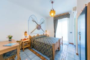 a bedroom with a bed and a table at Rooms B&B Albergo Riviera in Maiori