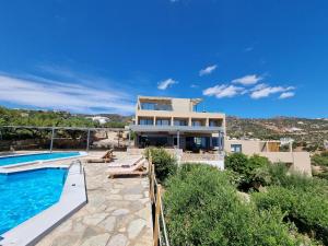 a villa with a swimming pool and a house at Meliti Hotel (Adults Only) in Agios Nikolaos