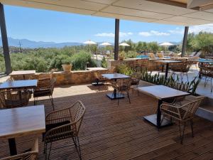un restaurante con mesas y sillas en una terraza en Meliti Hotel (Adults Only) en Ágios Nikólaos