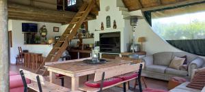 - un salon avec une table en bois et un canapé dans l'établissement Rosedale Self Catering Cottage with pool and large entertainment BBQ area, à Henburg Park