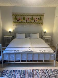 sypialnia z dużym łóżkiem z dwoma stołami w obiekcie TROLLEBO günstig gelegene renovierte Stuga mit Sauna und 250 Mbs Glasfaser w mieście Eriksmåla