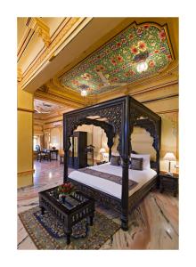 a bedroom with a canopy bed with a floral ceiling at Chunda Palace in Udaipur +42 photos