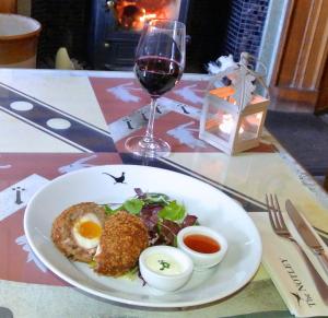 a plate of food with eggs and a glass of wine at Notley Arms Inn Exmoor National Park in Elworthy