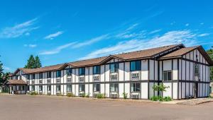 um grande edifício branco com um telhado castanho em Magnuson Hotel Ironwood em Ironwood