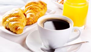 a cup of coffee and croissants on a table at Magnuson Hotel Ironwood in Ironwood