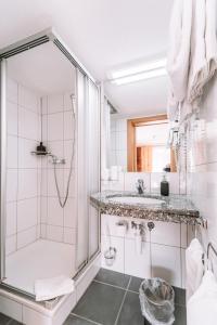 a bathroom with a shower and a sink at Hotel Les Amis in Saas-Fee