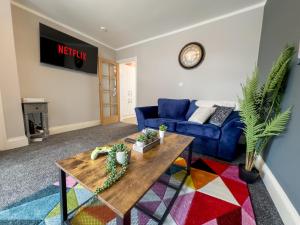 sala de estar con sofá azul y mesa en Stunning House Free Parking Garden WiFi en Bristol