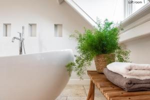 a bathroom with a tub and a plant on a bench at Boutique hotel Villa Oldenhoff in Abcoude +32 photos