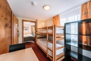 Zimmer mit 2 Etagenbetten und einem Tisch in der Unterkunft Hotel Les Amis in Saas-Fee