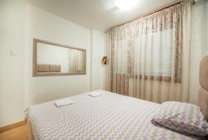 a small bedroom with a bed and a window at Apartman Vukcevic in Podgorica