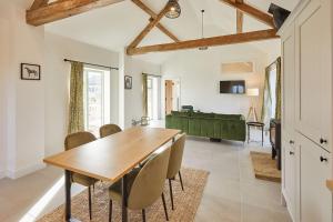 ein Esszimmer mit einem Holztisch und Stühlen in der Unterkunft The Stables Cottage in Yedingham