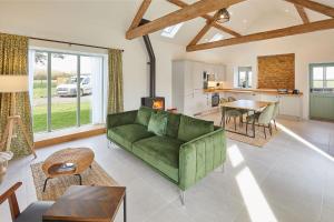 ein Wohnzimmer mit einer grünen Couch und einem Tisch in der Unterkunft The Stables Cottage in Yedingham