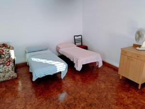 sala de estar con 2 camas y vestidor en Casa Centineo en Barcellona-Pozzo di Gotto