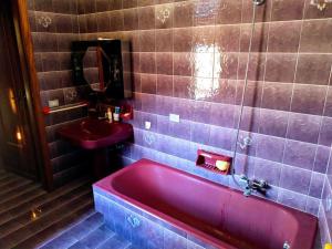 baño con bañera roja y lavamanos en Casa Centineo en Barcellona-Pozzo di Gotto