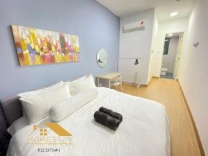 sypialnia z białym łóżkiem z czarnym przedmiotem w obiekcie Legasi Kampung Baru by Twenty7 w Kuala Lumpur
