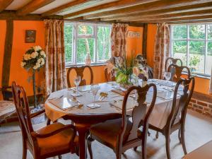 Tivetshall Saint Margaret的住宿－Tattlepot Farmhouse，一间带木桌和椅子的用餐室