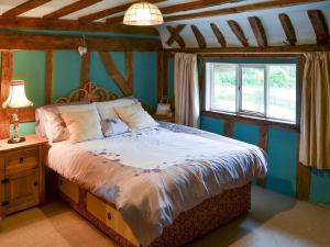 a bedroom with a bed and a window at Tattlepot Farmhouse in Tivetshall Saint Margaret