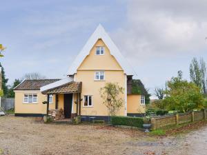 a yellow house with a pointed roof at Tattlepot Farmhouse in Tivetshall Saint Margaret