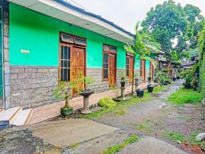 um edifício verde com uma rua em frente em OYO 91697 Nyaman Homestay Syariah em Pare