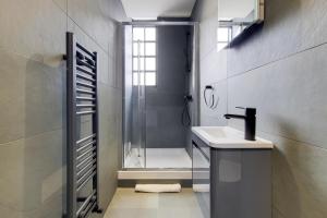 a bathroom with a shower and a sink and a toilet at Langdon Brooks Apartments in London