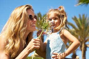 una mujer y una niña sosteniendo una flor en Iberostar Málaga Playa, en Torrox Costa