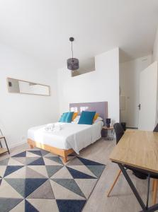 Artbleu -Tout Confort - Idéal Pros - Proche commerces في مونلوسون: غرفة نوم بسرير مع وسائد زرقاء وصفراء