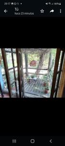 a picture of a porch with a table and a bench at La Estancia hostel in Colonia del Sacramento