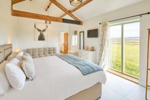 a bedroom with a large bed and a window at Wold's View Cottage in Yedingham