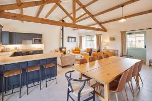 a kitchen and living room with a wooden table and chairs at Wold's View Cottage in Yedingham