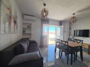 ein Wohnzimmer mit einem Sofa und einem Tisch in der Unterkunft Hello Sunshine - Apartment on the Beach in Zubovići