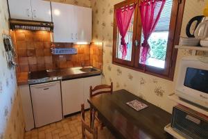 a small kitchen with a table and a microwave at CAMAT T1 de plain pied à la campagne in Cazaubon