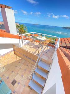 Un balcón con mesa y sillas y el mar. en Mundaka Vista Mar L-BI-52, en Mundaka