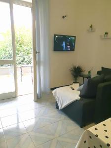 a living room with a couch and a tv on the wall at Le stanze di Angelina in Foligno
