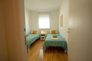 Habitación con 2 camas y ventana en WHITE FIELDS-Central 2-bdrm apartment with parking, en Novi Sad