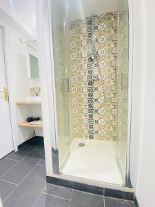 um chuveiro com uma porta de vidro na casa de banho em Appartement charmant em Laon