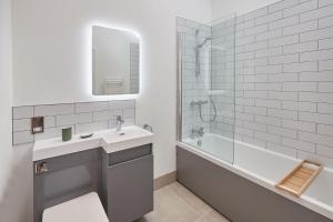 a white bathroom with a sink and a bath tub at Rose Cottage in Yedingham +6 photos