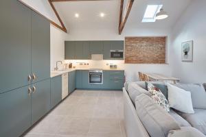 a kitchen and a living room with a couch at Rose Cottage in Yedingham