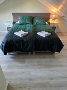 een slaapkamer met een bed met twee handdoeken erop bij Parnassia in De Koog