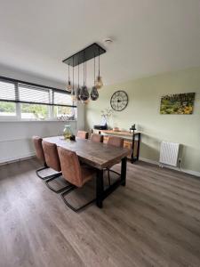 a dining room with a table and chairs and a clock at Parnassia in De Koog