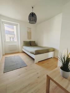 a white bedroom with a bed and a window at Quiet & Cosy near Loire River & Tramway in Nantes