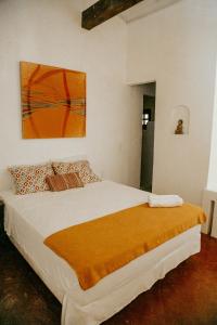 a bedroom with a large bed with a painting on the wall at Casa Nostra Trancoso in Trancoso