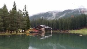 a cabin sitting on the edge of a lake at Chalet Al Lago in San Vito di Cadore