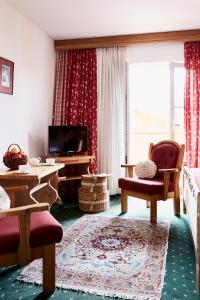 ein Wohnzimmer mit einem Sofa, einem Tisch und einem TV in der Unterkunft Gasthof-Hotel Dannerwirt in Flintsbach